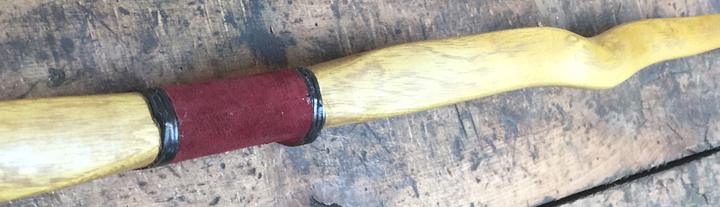 Holzbogen mit geschwungenem Griffbereich und roter Wicklung