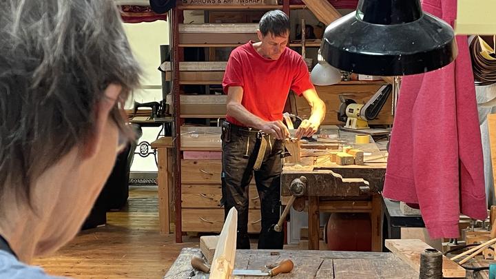 Kursteilnehmer an der Hobelbank in der Werkstatt