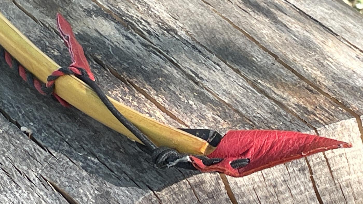 Wings Bogen aus Osage mit rotem Lederschmuck an der Spitze